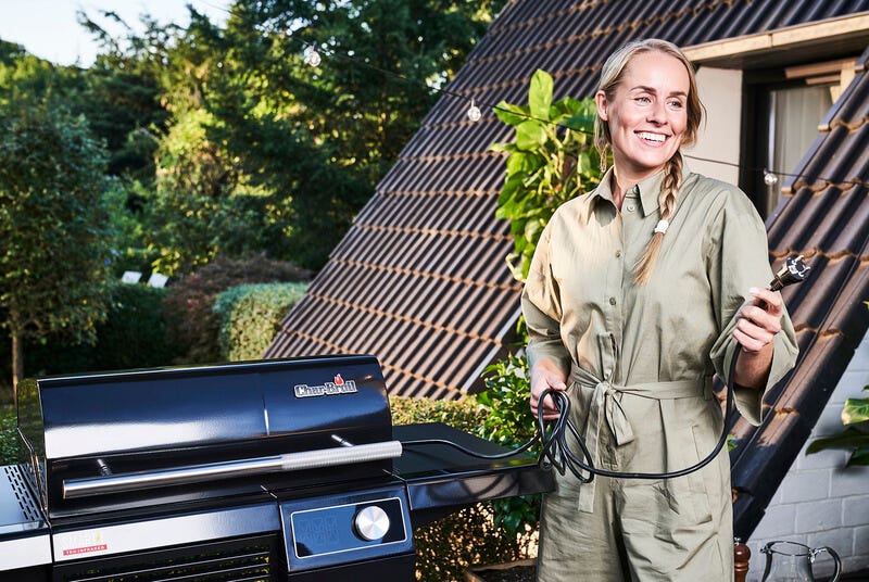 Elektrisch grillen mit SMART-E Frau hält Stromkabel vom SMART-E Elektrogrill